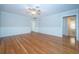 Bright living room featuring hardwood floors, wainscoting, a ceiling fan and access to other rooms at 209 S Greenfield Ave, Temple Terrace, FL 33617