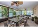 Inviting sunroom features large windows, ceiling fan, and comfortable seating area with a dining table at 209 S Greenfield Ave, Temple Terrace, FL 33617