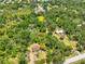 Expansive aerial view showcasing the property's wooded surroundings and proximity to a pond at 2112 33Rd Se St, Ruskin, FL 33570