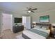Beautiful bedroom features a ceiling fan, hardwood flooring, and a large flat screen TV at 2112 33Rd Se St, Ruskin, FL 33570