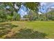 View of the exterior of the house with a spacious grassy yard surrounded by trees at 2112 33Rd Se St, Ruskin, FL 33570