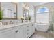 Bright bathroom featuring dual sinks, soaking tub, and glass enclosed shower at 2498 Saddlewood Ln, Palm Harbor, FL 34685
