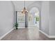Open dining room with wood-look tile flooring, chandelier and arched entryway at 2498 Saddlewood Ln, Palm Harbor, FL 34685