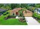 Charming single-story home with lush landscaping, red door and well-maintained lawn at 2498 Saddlewood Ln, Palm Harbor, FL 34685