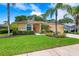 Charming home with manicured lawn, lush landscaping, and a three-car garage at 2498 Saddlewood Ln, Palm Harbor, FL 34685