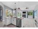 Open kitchen with stainless steel appliances, island and view of the pool and living area at 2498 Saddlewood Ln, Palm Harbor, FL 34685