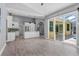 An open-concept living room and kitchen with wood-look floors and sliding glass doors to outdoor space at 2498 Saddlewood Ln, Palm Harbor, FL 34685