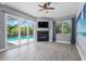 Bright living room boasts a fireplace, ceiling fan, and sliding glass doors to a pool at 2498 Saddlewood Ln, Palm Harbor, FL 34685