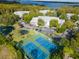 Aerial view of condos, parking, pond and tennis courts within a lake community at 2533 Dolly Bay Dr # 203, Palm Harbor, FL 34684