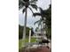 Beautiful backyard featuring lush landscaping, tall palm trees, sitting area and barbecue at 2533 Dolly Bay Dr # 203, Palm Harbor, FL 34684