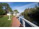 Private dock with white railings leading to waterfront property with lush green lawn at 2533 Dolly Bay Dr # 203, Palm Harbor, FL 34684