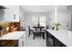 Bright eat-in kitchen features white cabinets, stainless appliances, quartz counters, and a dining nook at 2533 Dolly Bay Dr # 203, Palm Harbor, FL 34684