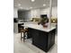 An open-concept kitchen featuring white cabinets, modern appliances, an island, and stylish backsplash at 2533 Dolly Bay Dr # 203, Palm Harbor, FL 34684