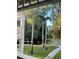 Lush view from the covered outdoor patio including tall palm trees and a glimpse of water at 2533 Dolly Bay Dr # 203, Palm Harbor, FL 34684