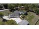 An aerial view showcases this home complete with a pool, screened-in lanai, separate carport, and a long driveway at 27709 Robin Roost Ln, Wesley Chapel, FL 33544