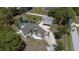 An aerial view showcases this beautiful home featuring a pool, screened-in lanai, separate carport, and a long driveway at 27709 Robin Roost Ln, Wesley Chapel, FL 33544