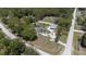 Aerial view of a gray roof house with a detached garage and trees in the yard at 27709 Robin Roost Ln, Wesley Chapel, FL 33544