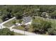 An aerial view shows the house, wooden fence, driveway and mature trees along the road at 27709 Robin Roost Ln, Wesley Chapel, FL 33544