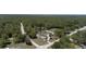 Aerial view of the house, surrounded by a lush forest, with street access on two sides at 27709 Robin Roost Ln, Wesley Chapel, FL 33544