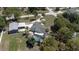 Aerial view of a gray roof house with a detached garage and screened pool in the yard at 27709 Robin Roost Ln, Wesley Chapel, FL 33544