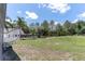 A vast, green backyard features an expansive lawn and mature trees, perfect for outdoor enjoyment at 27709 Robin Roost Ln, Wesley Chapel, FL 33544