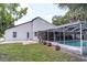 Rear view of the house featuring a screened lanai and swimming pool at 27709 Robin Roost Ln, Wesley Chapel, FL 33544