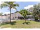 Backyard featuring a screened pool, patio, well-maintained lawn, and lush landscaping at 27709 Robin Roost Ln, Wesley Chapel, FL 33544
