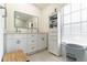 Bright bathroom features a double vanity, a lighted mirror and a storage cabinet at 27709 Robin Roost Ln, Wesley Chapel, FL 33544