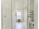 Hallway with bath and laundry room with tiled floors and white doors at 27709 Robin Roost Ln, Wesley Chapel, FL 33544