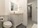 Modern bathroom with a toilet and white vanity with an illuminated mirror and a walk-in closet at 27709 Robin Roost Ln, Wesley Chapel, FL 33544