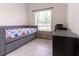 Neutral bedroom featuring a gray daybed, natural light, and side table with drawers at 27709 Robin Roost Ln, Wesley Chapel, FL 33544