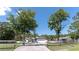 Lovely single-Gathering home featuring a long driveway, a well-manicured lawn, and mature landscaping with palm trees at 27709 Robin Roost Ln, Wesley Chapel, FL 33544