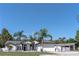 Beautiful home with a two-car garage, well-manicured lawn, palm trees, and modern exterior paint at 27709 Robin Roost Ln, Wesley Chapel, FL 33544