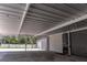 Spacious carport area with roll up door access, and string lights, providing ample space for parking and storage at 27709 Robin Roost Ln, Wesley Chapel, FL 33544