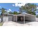 Spacious garage with roll-up doors and carport, ideal for storage and projects on a sunny day at 27709 Robin Roost Ln, Wesley Chapel, FL 33544