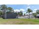 Large garage with an outdoor workspace area in a spacious backyard with green grass and mature trees at 27709 Robin Roost Ln, Wesley Chapel, FL 33544