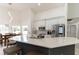 Modern kitchen featuring a breakfast bar with seating and stainless steel appliances overlooking the dining room at 27709 Robin Roost Ln, Wesley Chapel, FL 33544