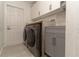 Well-equipped laundry room with modern appliances, cabinetry, and countertop space at 27709 Robin Roost Ln, Wesley Chapel, FL 33544