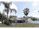 View of a screened-in pool with mature landscaping, offering a private oasis at 27709 Robin Roost Ln, Wesley Chapel, FL 33544