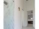 Modern shower with glass enclosure and marble wall tiling, and a bedroom in the background at 27709 Robin Roost Ln, Wesley Chapel, FL 33544