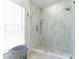 Modern tiled shower with glass enclosure, pebble floor and chrome fixtures at 27709 Robin Roost Ln, Wesley Chapel, FL 33544