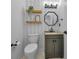 Stylish half bathroom featuring modern fixtures, patterned wallpaper, wood shelving and a granite-topped vanity at 3002 Savannah Oaks Cir, Tarpon Springs, FL 34688