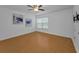 Bright bedroom featuring wood flooring, ceiling fan and a window with natural light at 3002 Savannah Oaks Cir, Tarpon Springs, FL 34688