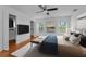 Updated bedroom features wood-look floors, ceiling fan, and a comfortable bed with bench seating at 3002 Savannah Oaks Cir, Tarpon Springs, FL 34688