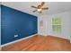 This bedroom features wood-look floors and a blue accent wall at 3002 Savannah Oaks Cir, Tarpon Springs, FL 34688