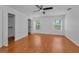 Bright bedroom features wood-look flooring, a ceiling fan, walk-in closets and two windows at 3002 Savannah Oaks Cir, Tarpon Springs, FL 34688