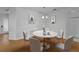 Staged dining room featuring a white table and chairs, chair rail detail, and laminate wood flooring at 3002 Savannah Oaks Cir, Tarpon Springs, FL 34688