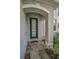 Inviting entryway with tile flooring, arched alcove, neutral color scheme, and sheltered entry with storm door at 3002 Savannah Oaks Cir, Tarpon Springs, FL 34688