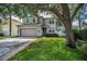 Exterior shot of a well maintained two story home with a neutral color scheme, two car garage and trimmed windows at 3002 Savannah Oaks Cir, Tarpon Springs, FL 34688