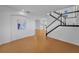 Bright foyer featuring a staircase with black handrail and light wood laminate flooring throughout at 3002 Savannah Oaks Cir, Tarpon Springs, FL 34688
